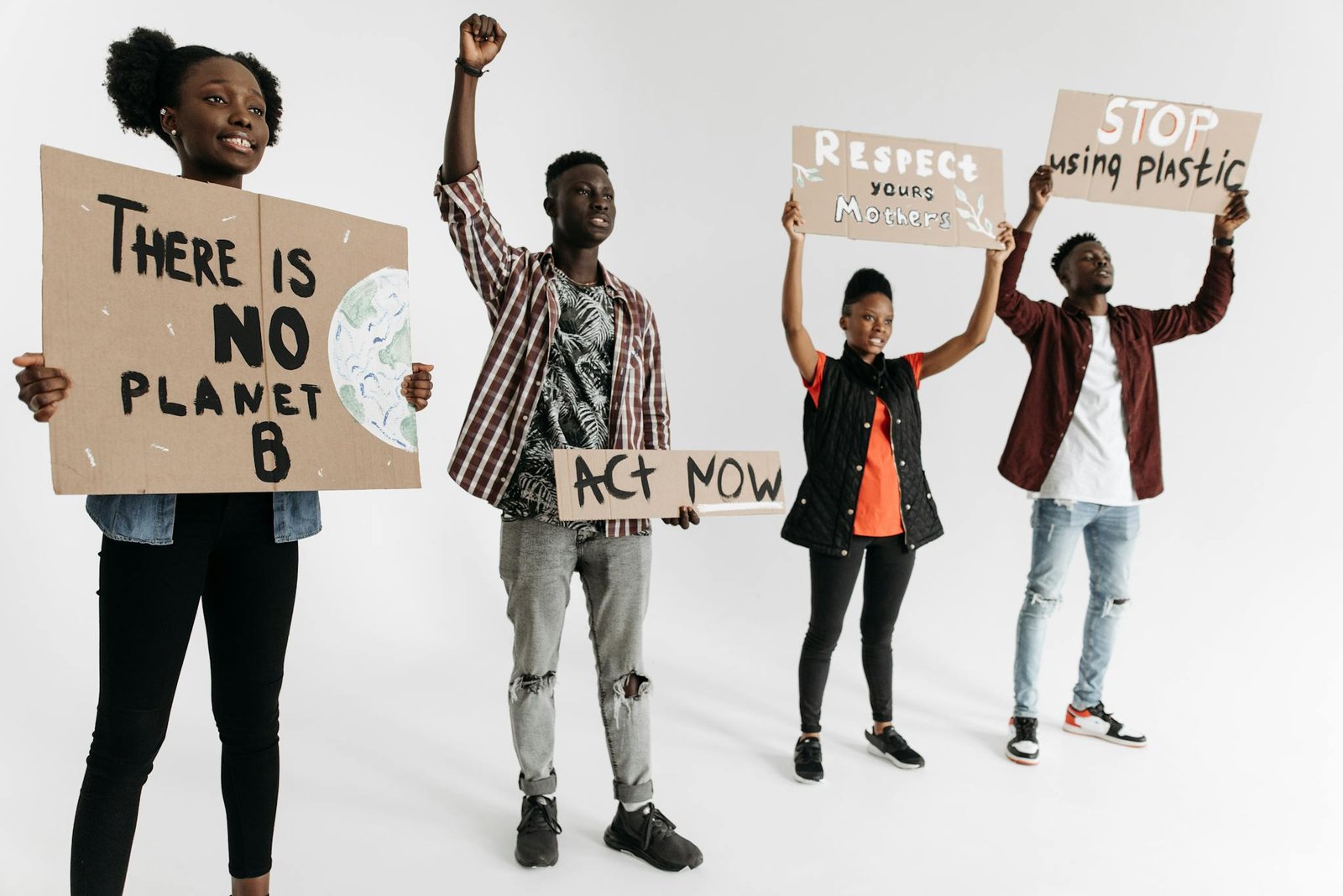 Diverse group of young adults holding environmental protest signs indoors on a white background.