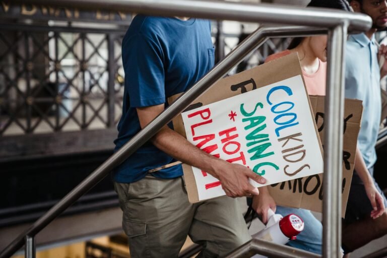 Group of activists holding signs advocating for climate change awareness in urban setting.