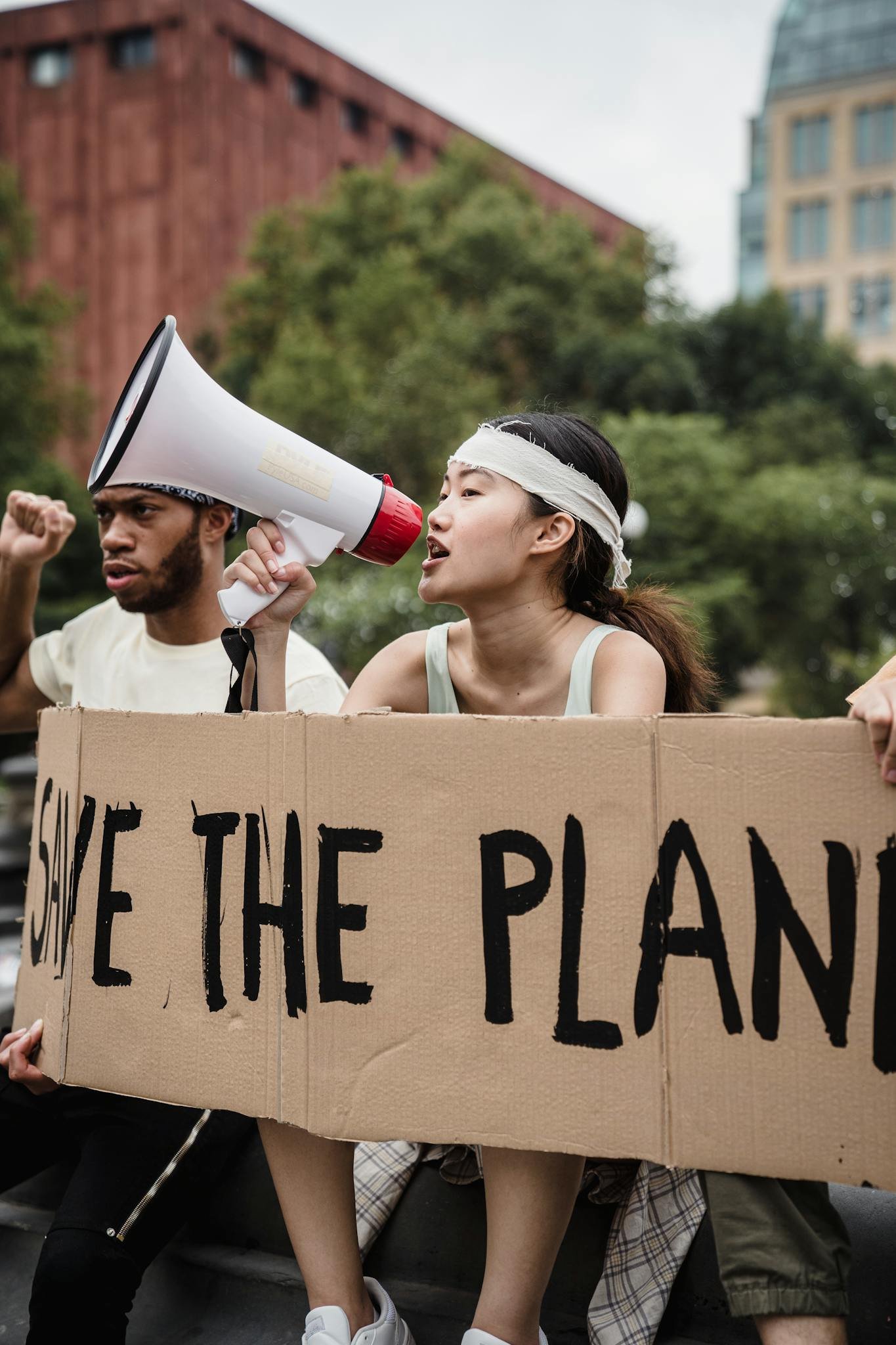 Young activists rally for climate change awareness with megaphone and sign.
